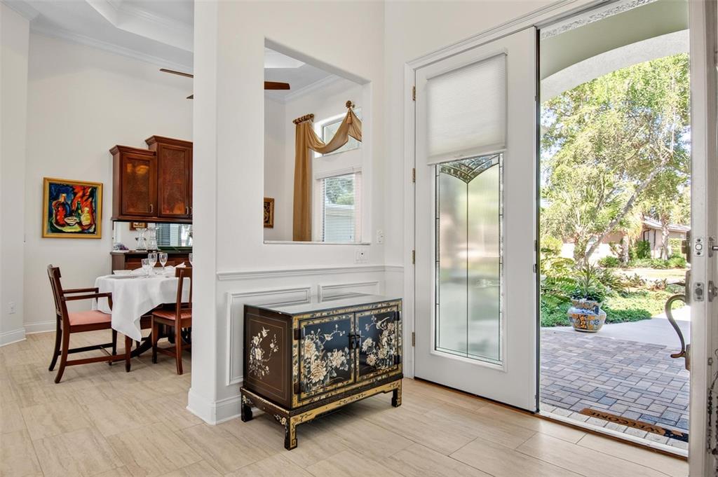 An entryway with a decorative cabinet, a pass-through window, and a glass door to a patio — 10 S WATERVIEW DRIVE, PALM COAST, FL