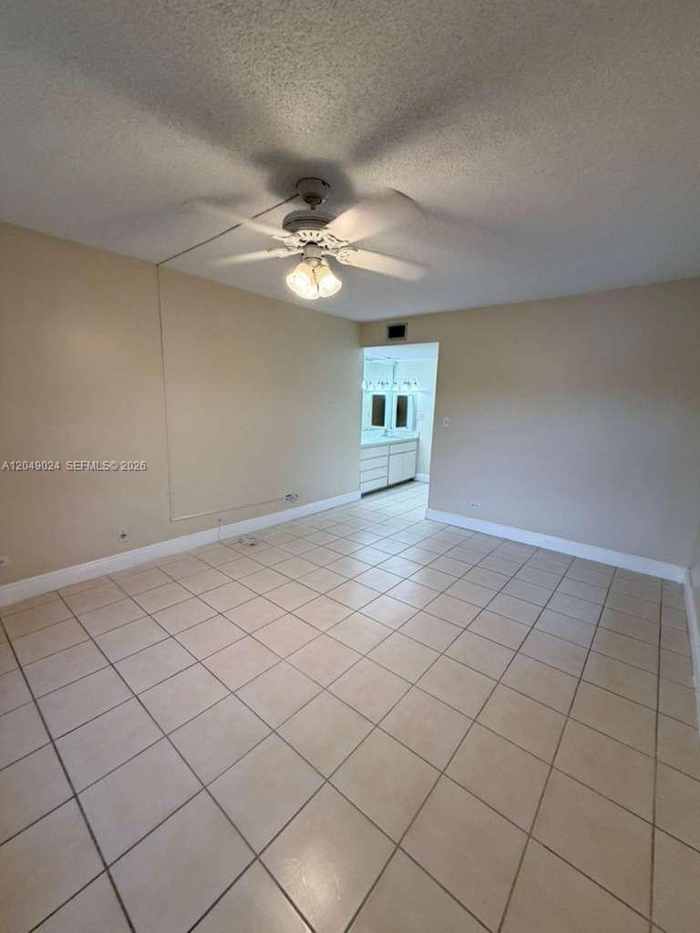 A room with beige walls, a ceiling fan, and light-colored tile flooring — 3720 Inverrary Dr # 3L, Lauderhill FL 33319, LAUDERHILL, FL