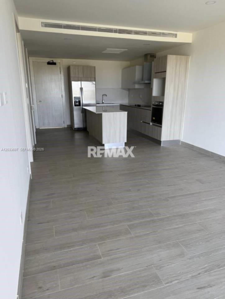 A modern kitchen with light wood cabinetry and a central island sits in an open-plan room — 605 Vermon # 605, FL, FL