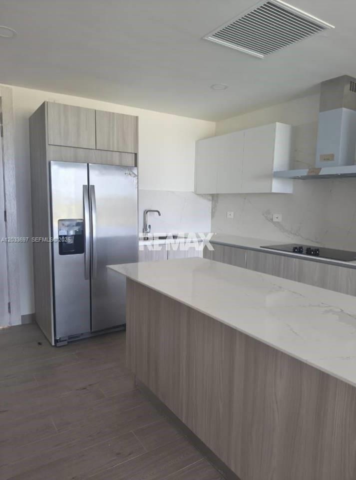 A modern kitchen features light wood cabinetry, a white island, and stainless steel appliances — 605 Vermon # 605, FL, FL