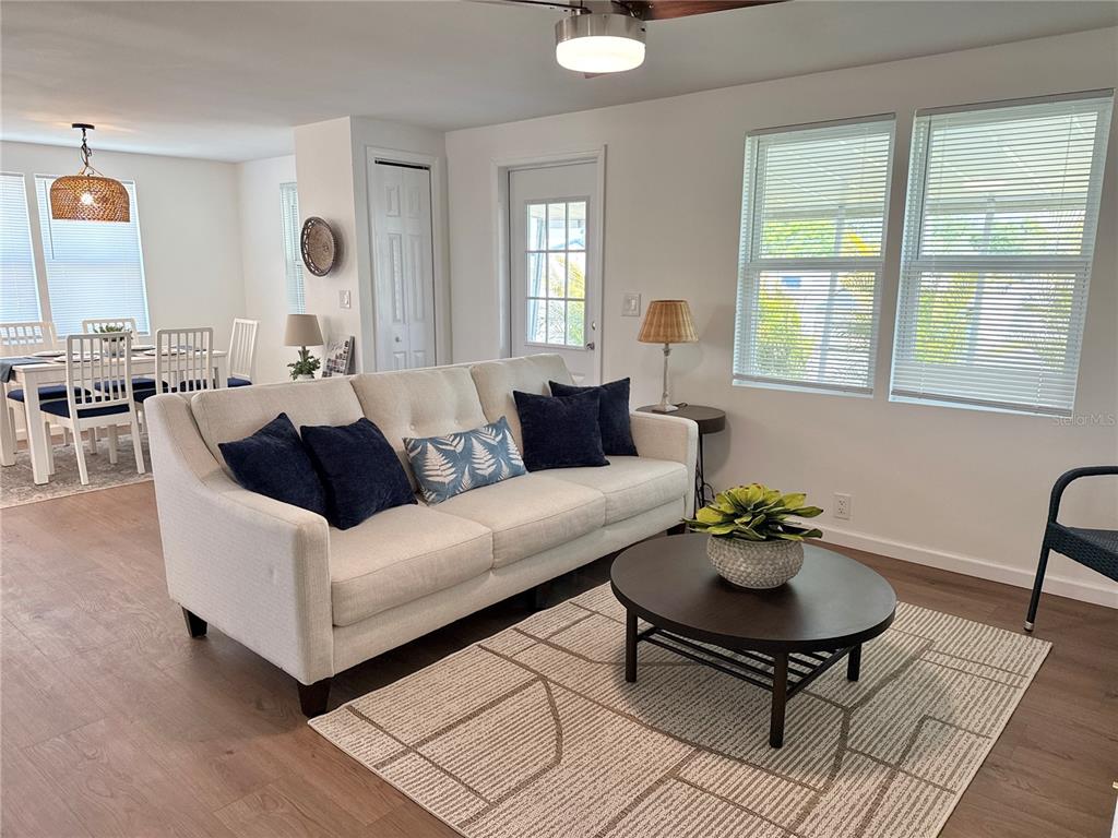 A living room features a light-colored sofa, a round coffee table, and an adjacent dining area — 7271 MOUNT ARLINGTON DRIVE NE UNIT 430, ST PETERSBURG, FL