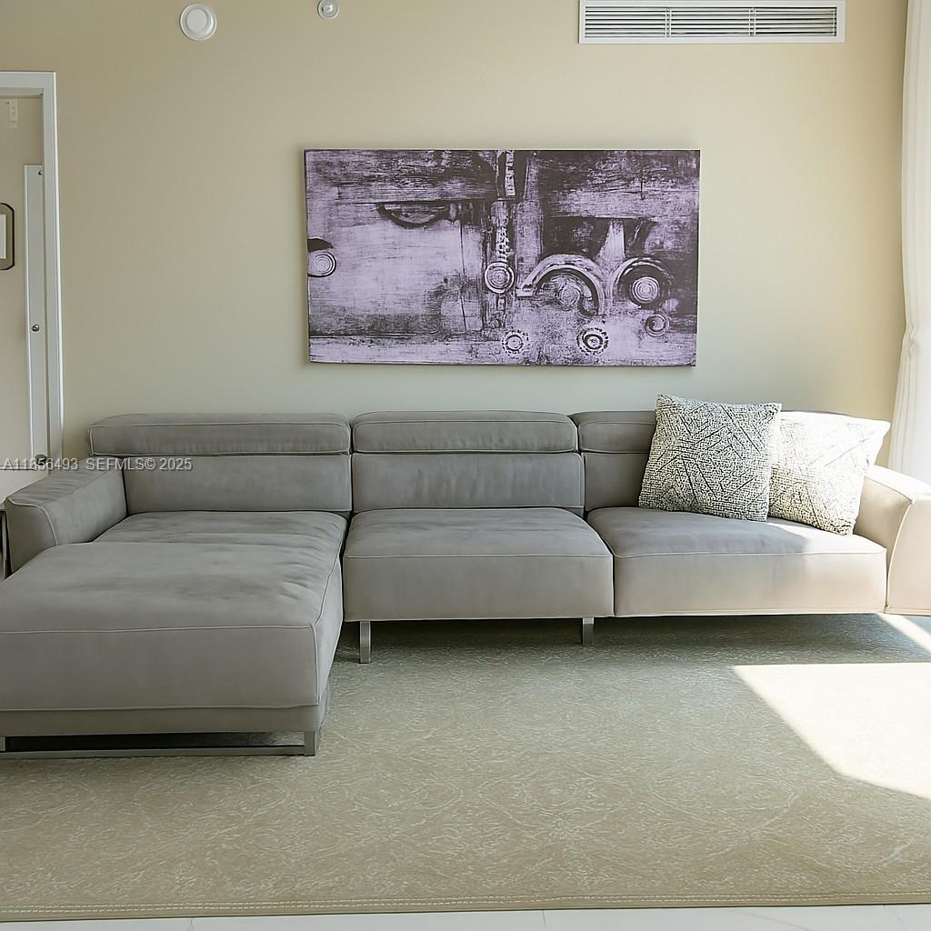 A gray sectional sofa sits on a light rug beneath abstract wall art — 250 Sunny Isles Blvd # 1506, Sunny Isles Beach FL 33160, SUNNY ISLES BEACH, FL