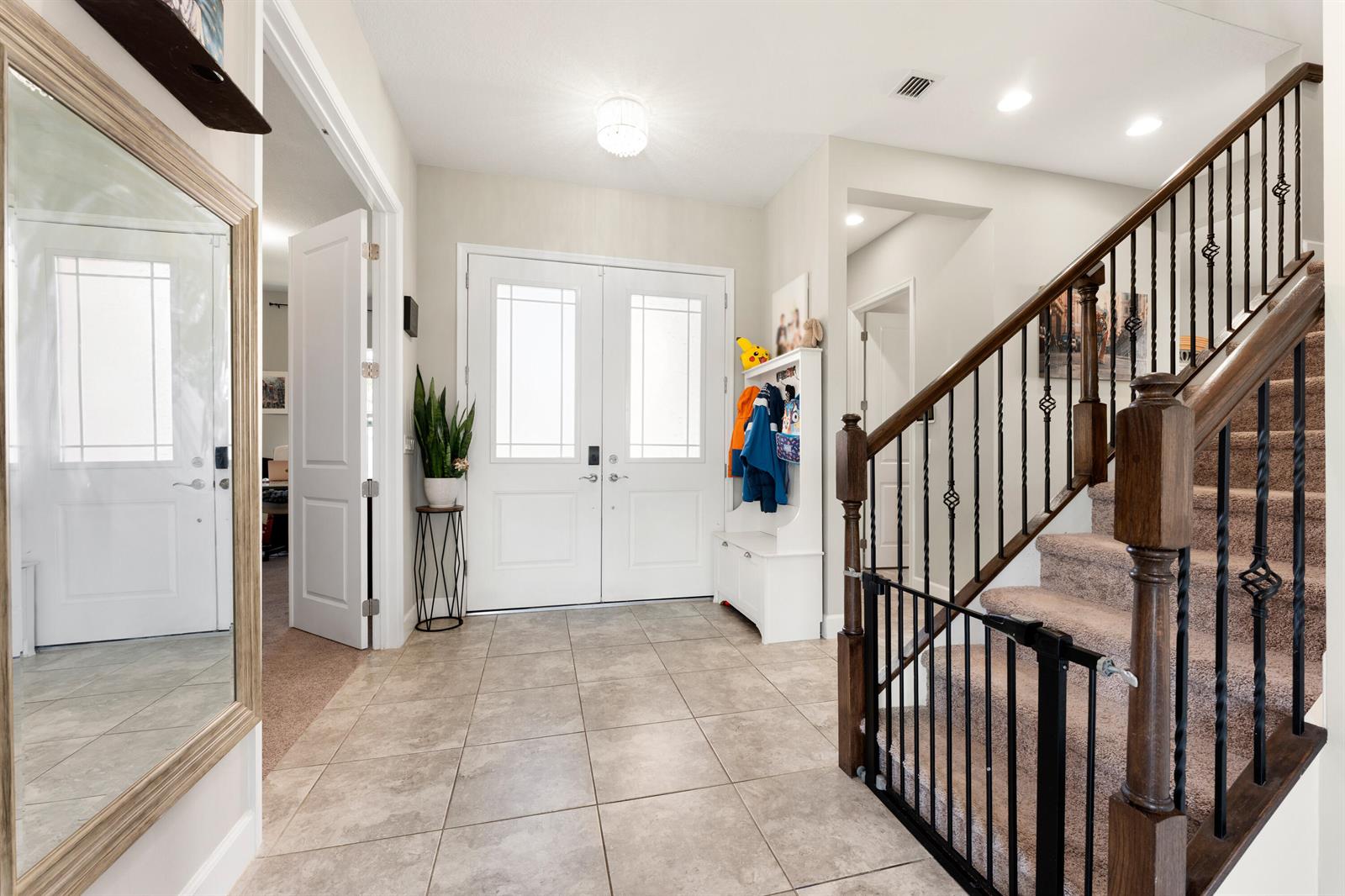 A tiled entryway features a double front door, a staircase with a railing, and a mirror — 5446 Macoon Way, Westlake FL 33470, WESTLAKE, FL