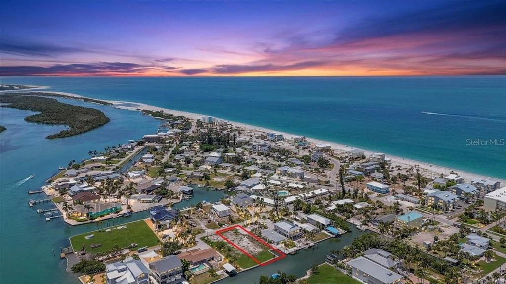 An aerial view shows a vacant waterfront lot outlined in red within a coastal neighborhood — 190 MOCKINGBIRD LANE, ENGLEWOOD, FL