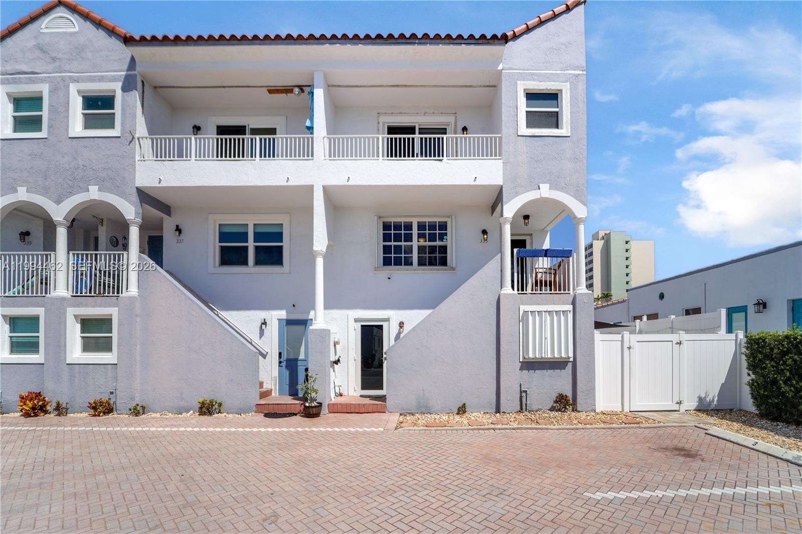 A multi-story residential building features a paved parking area, balconies, and white stucco exterior walls — 335 Virginia St, Hollywood FL 33019, HOLLYWOOD, FL