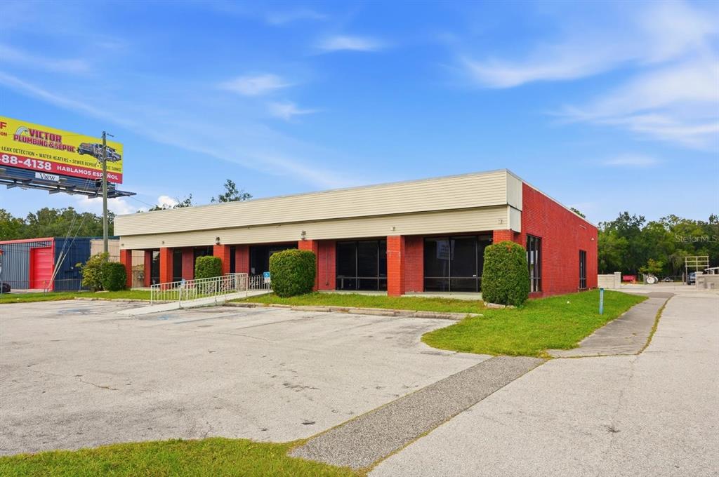 A single-story red brick commercial building with a flat roof and a paved parking lot — 4830 US HIGHWAY 92 E, LAKELAND, FL