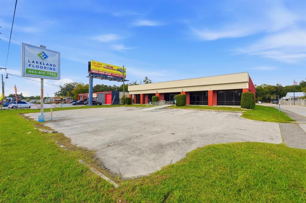 A commercial building with a large parking lot and two prominent advertising signs — 4830 US HIGHWAY 92 E, LAKELAND, FL