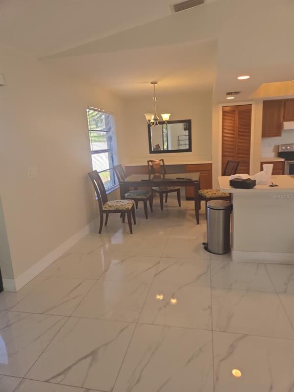 A dining area with a table, chairs, and white marble-look tile flooring — 1805 CORAL POINT DRIVE, CAPE CORAL, FL