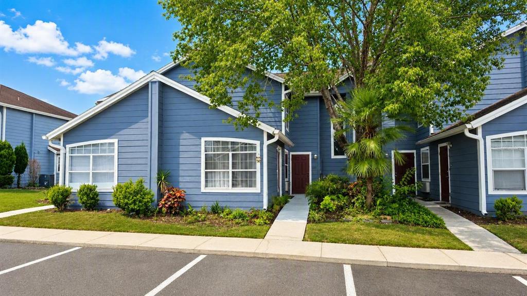 A kitchen features white cabinets, stainless steel appliances, a breakfast bar, and an adjacent laundry unit — 225 MANGO DRIVE, DAVENPORT, FL