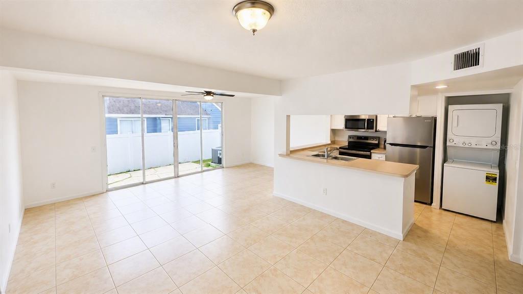 An open-concept living area features light-colored tile flooring and a raised dining space — 225 MANGO DRIVE, DAVENPORT, FL