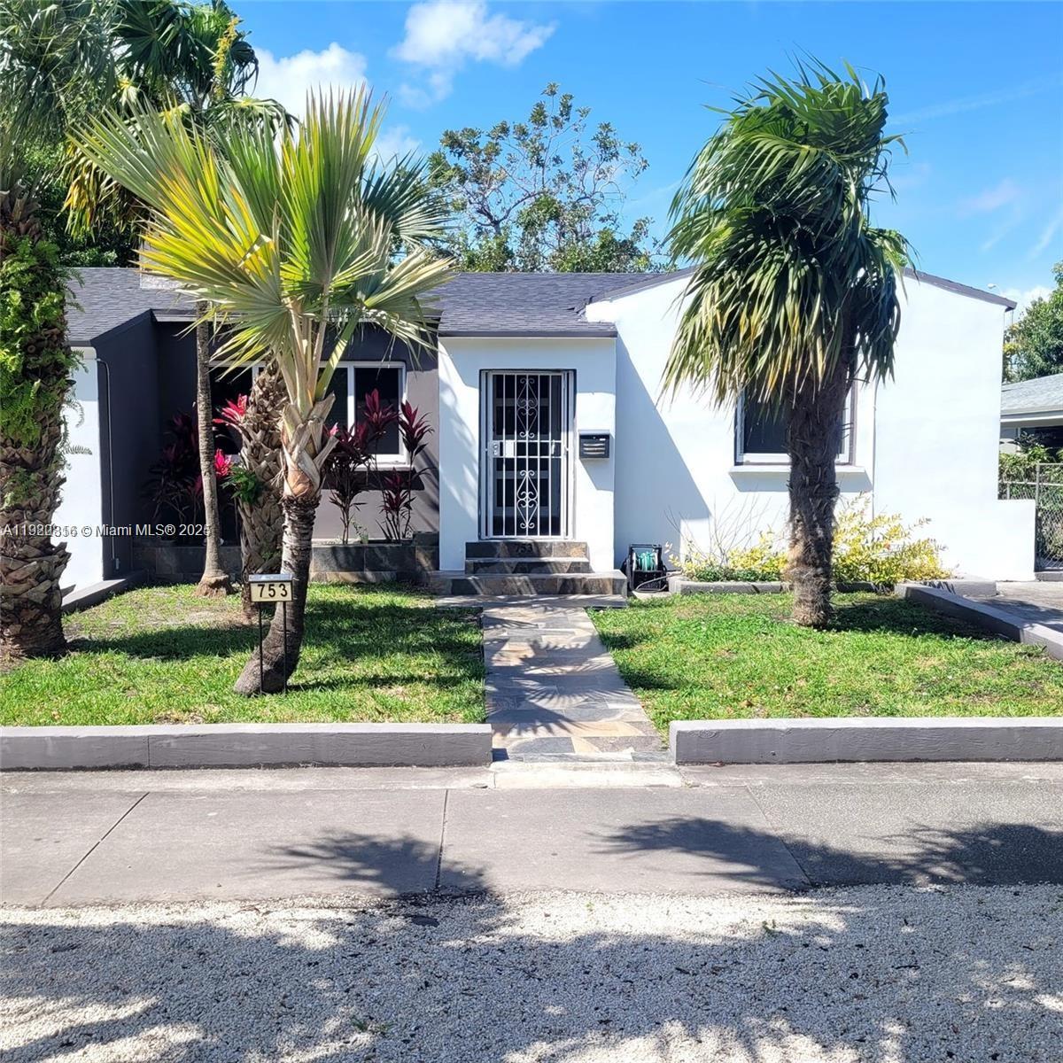 A single-story house with a white exterior, a stone walkway, and two prominent palm trees — 753 NE 81st St, Miami FL 33138, MIAMI, FL