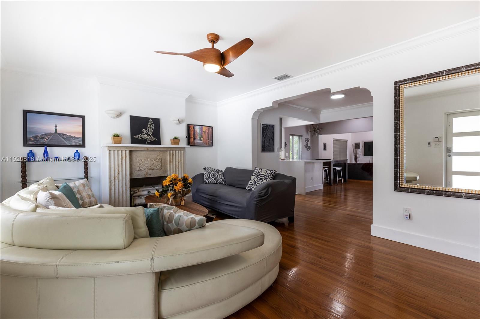 A living room features a fireplace, a curved white sofa, and hardwood flooring — 753 NE 81st St, Miami FL 33138, MIAMI, FL