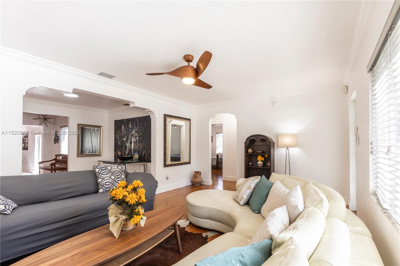 A living room features a curved white sofa, a grey sofa, and a wood ceiling fan — 753 NE 81st St, Miami FL 33138, MIAMI, FL