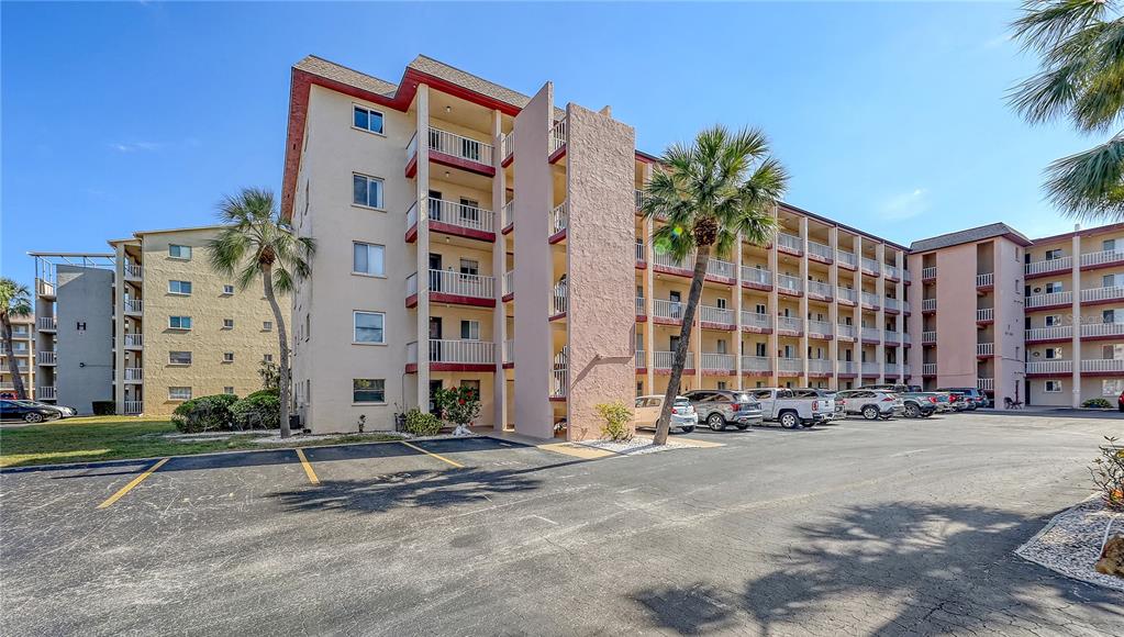 A multi-story apartment building with exterior balconies and a parking lot in the foreground — 3845 LAKE BAYSHORE DRIVE UNIT F103, BRADENTON, FL