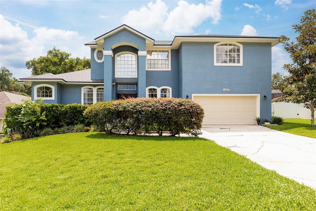 A two-story blue house with a two-car garage and a large front lawn — 1153 OAK TREE CIRCLE, ALTAMONTE SPRINGS, FL
