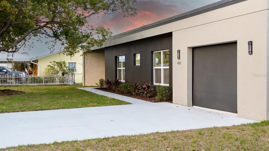 A modern, single-story house exterior features a dark vertical-siding facade, a garage, and a driveway — 455 RIVERVIEW AVENUE, SANFORD, FL