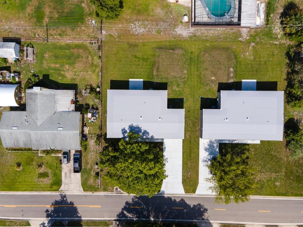 An aerial view shows two adjacent houses with gray roofs and concrete driveways — 455 RIVERVIEW AVENUE, SANFORD, FL