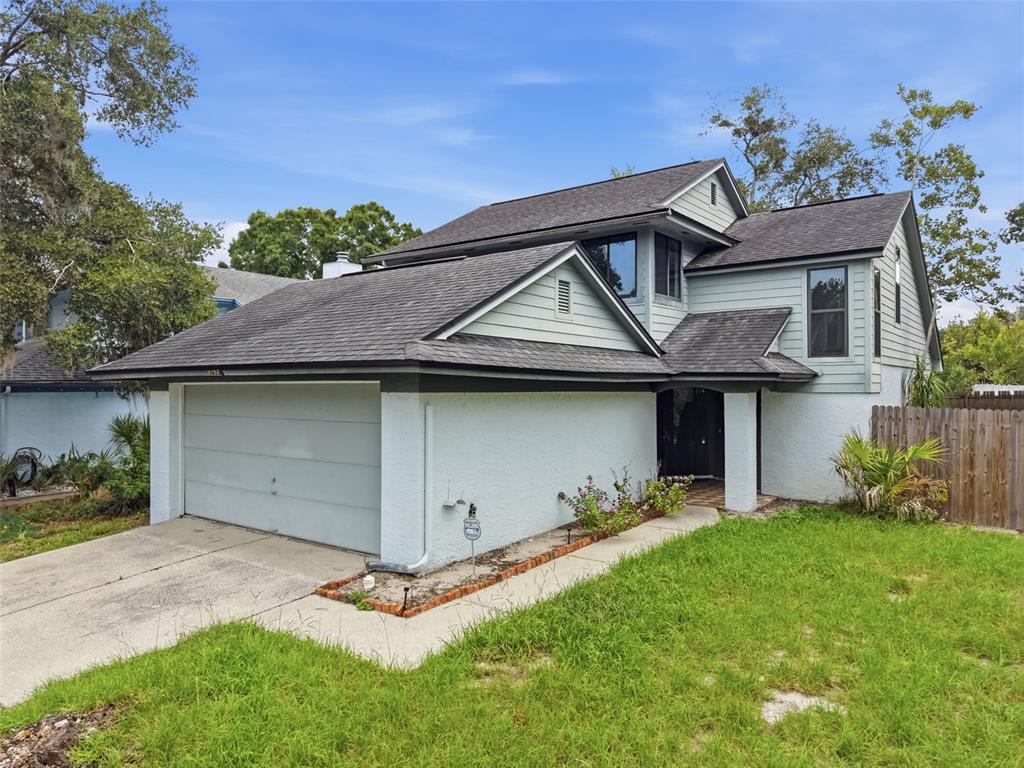 A two-story house with a light blue exterior, a garage, and a shingled roof — 3635 S SAINT LUCIE DRIVE, CASSELBERRY, FL