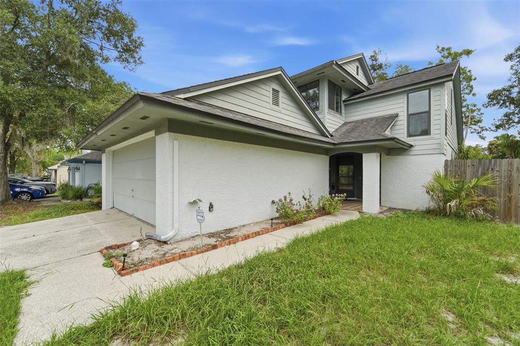 A two-story house with a white stucco exterior, gray siding, and an attached two-car garage — 3635 S SAINT LUCIE DRIVE, CASSELBERRY, FL