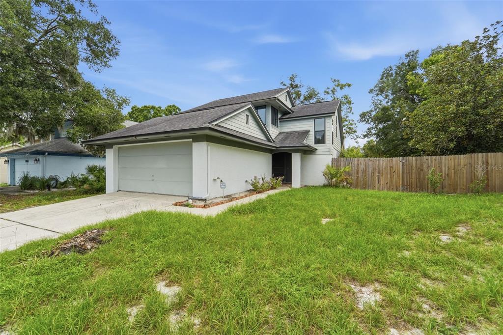 A two-story house with a light-colored exterior, a two-car garage, and a grassy front yard — 3635 S SAINT LUCIE DRIVE, CASSELBERRY, FL