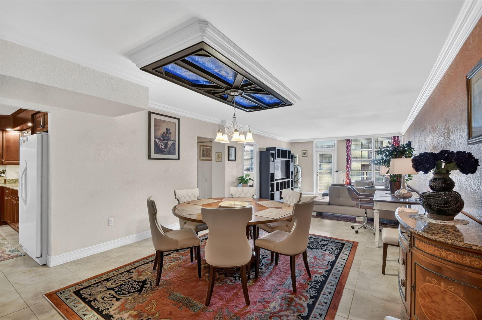 A dining room features a round table, a decorative ceiling light fixture, and a patterned rug — 3450 S Ocean Boulevard # 520, Palm Beach FL 33480, PALM BEACH, FL