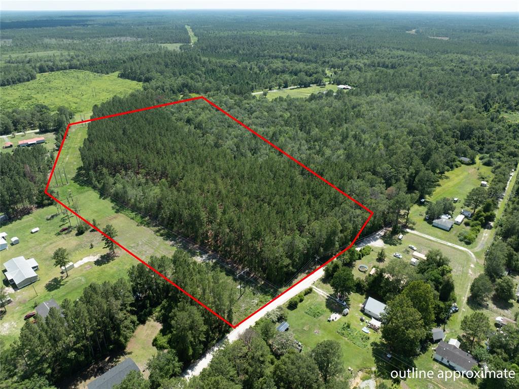 An aerial view shows a rectangular plot of forested land outlined in red — NW 185TH STREET, STARKE, FL