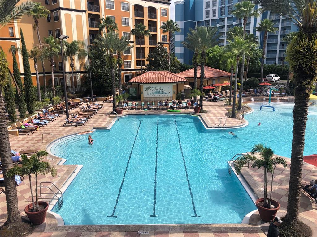 An outdoor swimming pool with lap lanes surrounded by lounge chairs and palm trees — 12544 FLORIDAYS RESORT DRIVE UNIT 612B, ORLANDO, FL