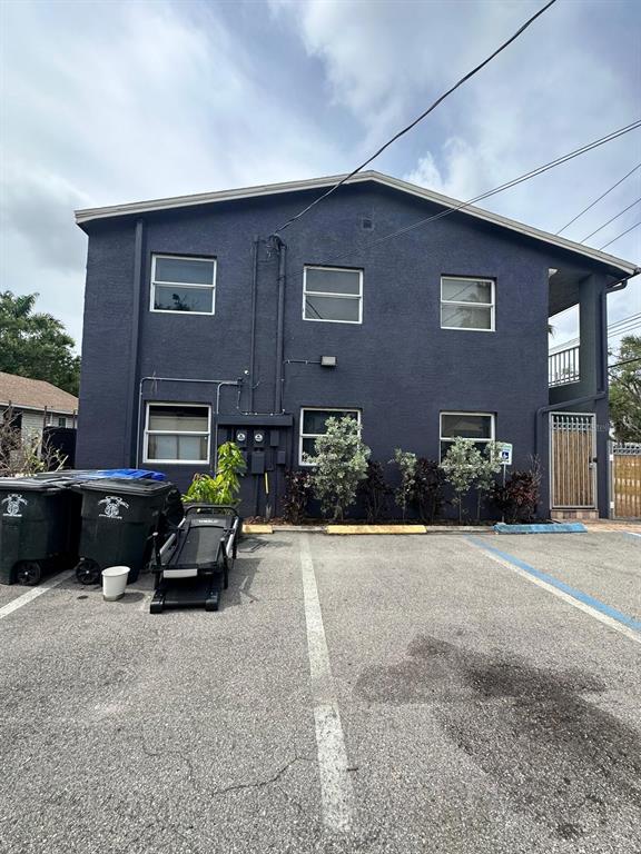 A two-story dark blue building with a parking lot and trash bins in front — 2251 GRAND AVENUE, FORT MYERS, FL