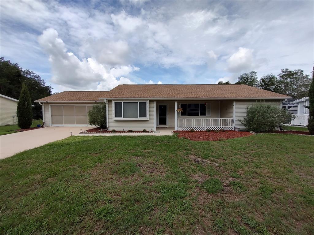 A single-story house with light siding, a brown shingled roof, and an attached garage — 11440 SW 84TH AVENUE ROAD, OCALA, FL