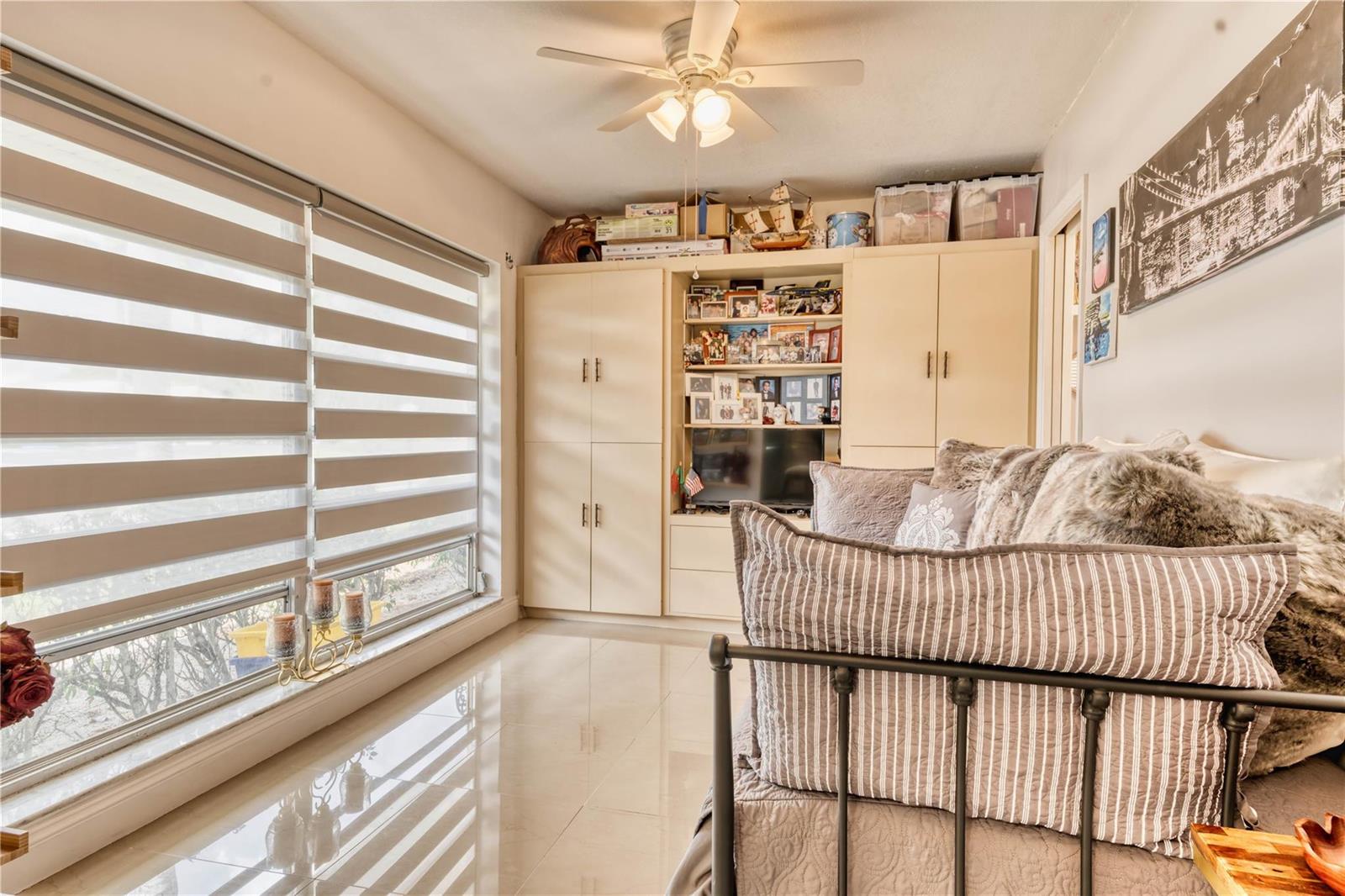 A bedroom features a daybed, built-in storage cabinets, a ceiling fan, and large windows — 8751 Chevy Chase Drive # 150, Boca Raton FL 33433, BOCA RATON, FL