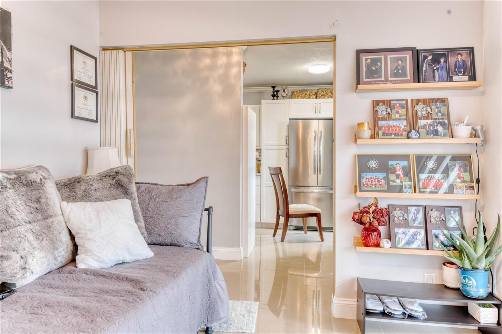 A living area with a daybed opens into a kitchen featuring stainless steel appliances — 8751 Chevy Chase Drive # 150, Boca Raton FL 33433, BOCA RATON, FL