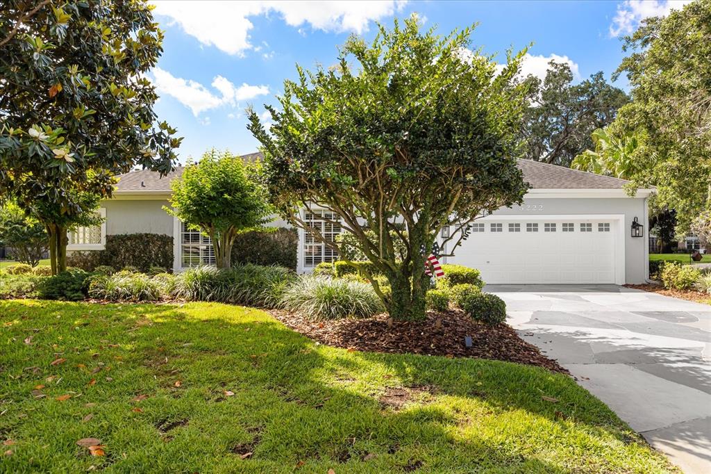A single-story house with a white garage, gray exterior, and a landscaped front yard — 5222 HAMMOCK POINTE COURT, ST CLOUD, FL
