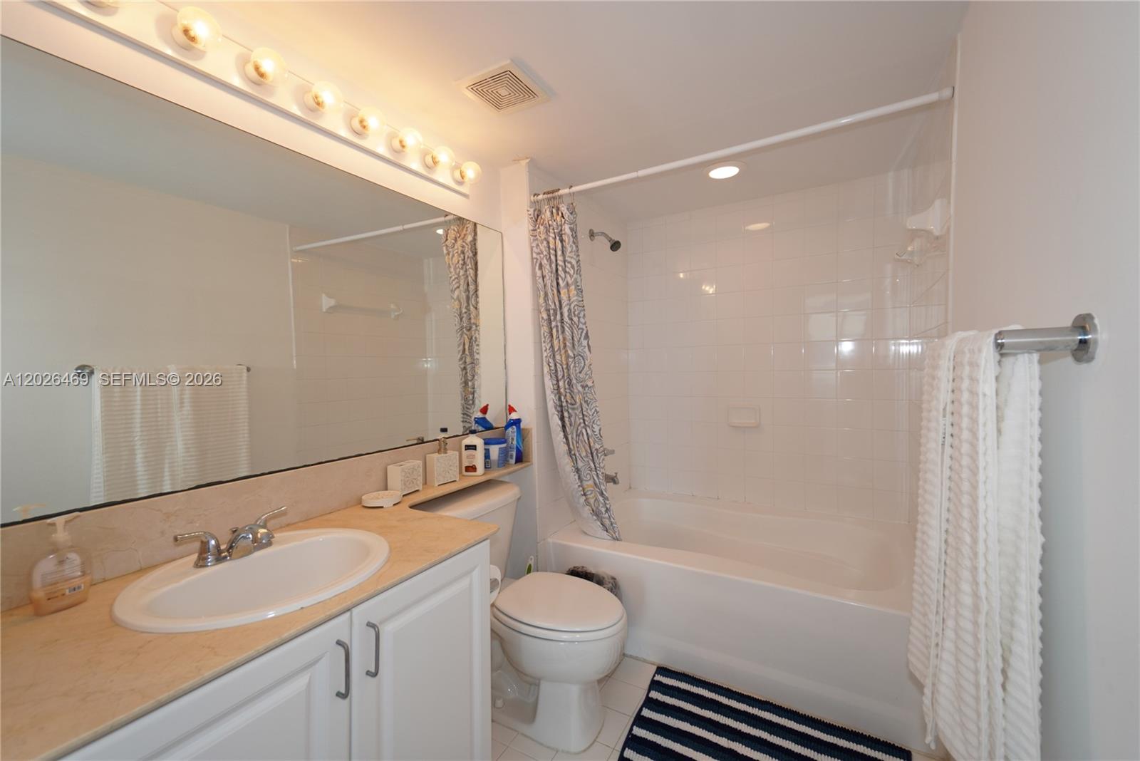 A bathroom features a white vanity, a toilet, and a shower-tub combination with white tiles — 1155 Brickell Bay Dr # 3301, Miami FL 33131, MIAMI, FL