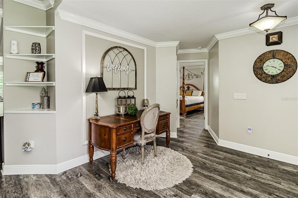A home office area features a wooden desk, a chair, and built-in wall shelving — 5864 MANCHESTER DRIVE W, LAKELAND, FL
