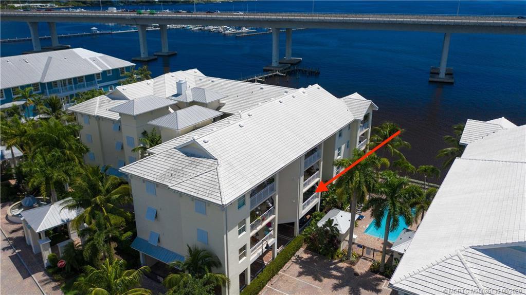 An aerial view shows a multi-story residential building with balconies next to a bridge — 275 NW Flagler Avenue # 205, Stuart FL 34994, STUART, FL
