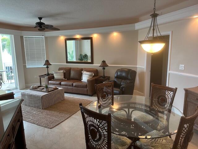 A living and dining area featuring a leather sofa, glass-topped table, and ceiling fan — 275 NW Flagler Avenue # 205, Stuart FL 34994, STUART, FL