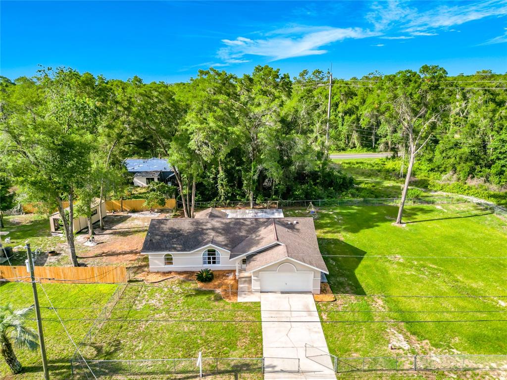 An aerial view shows a single-story house with a brown roof and a concrete driveway — 6110 E WINGATE STREET, INVERNESS, FL