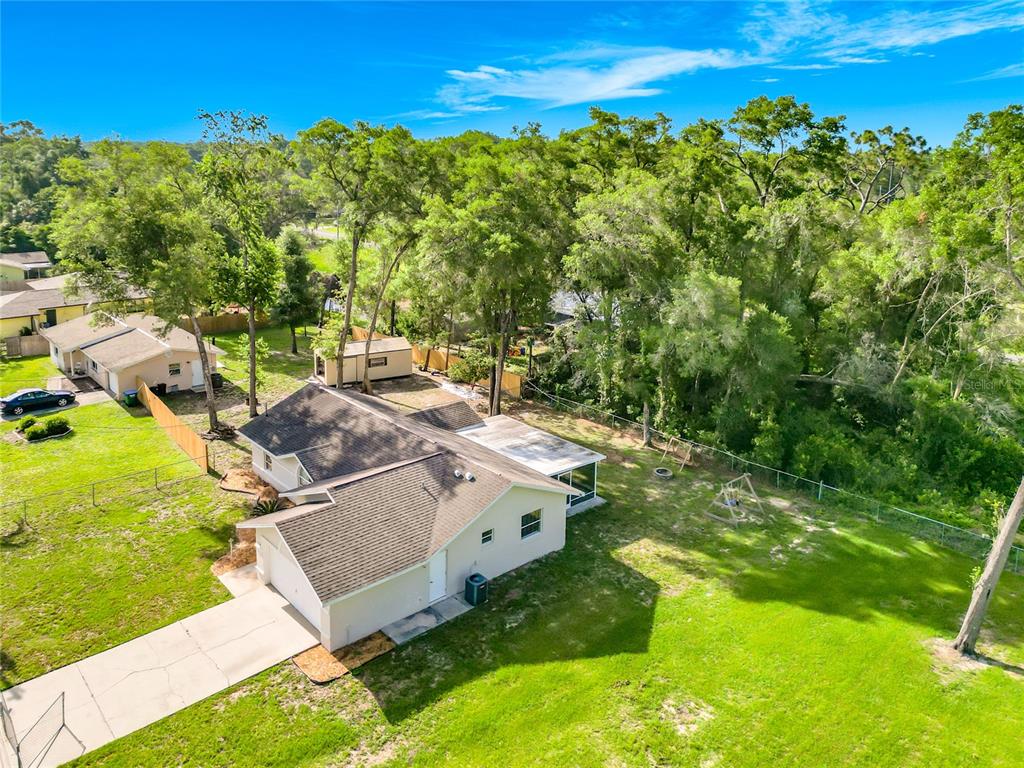 An aerial view shows a single-story house with a driveway, backyard, and surrounding trees — 6110 E WINGATE STREET, INVERNESS, FL