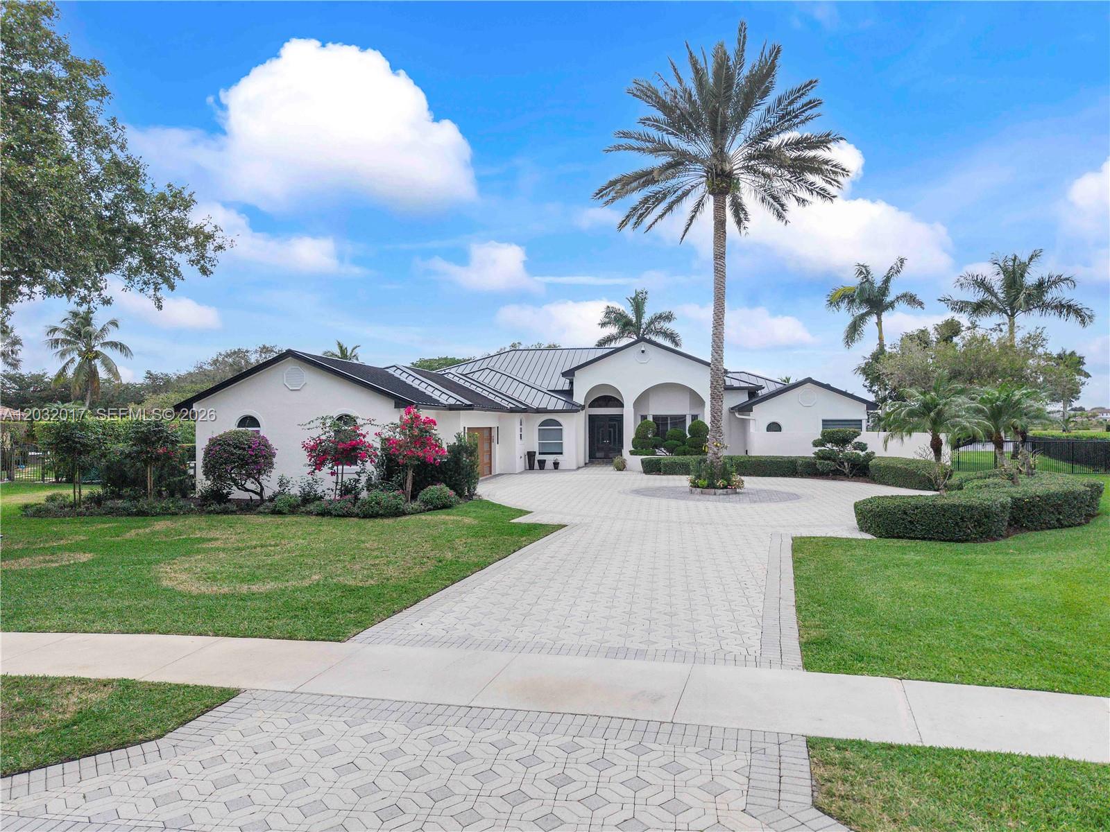 A single-story white house with a metal roof and a large paved circular driveway — 2235 SW 105th Ter, Davie FL 33324, DAVIE, FL