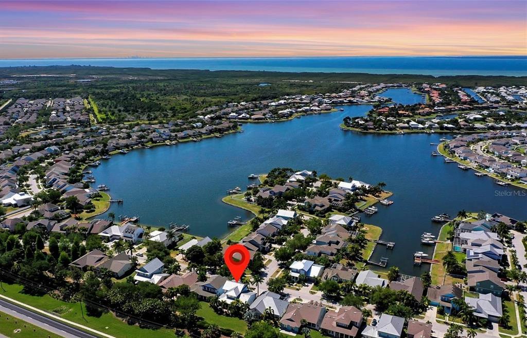 An aerial view shows a residential neighborhood with houses surrounding a large lake — 416 MANNS HARBOR DRIVE, APOLLO BEACH, FL