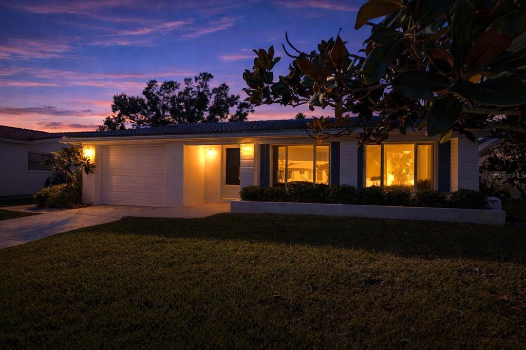 A single-story house with a garage and illuminated windows at dusk — 9306 42ND STREET N, PINELLAS PARK, FL