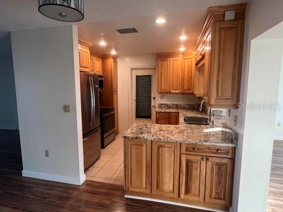 A kitchen features wood cabinets, granite countertops, stainless steel appliances, and a tiled floor — 9306 42ND STREET N, PINELLAS PARK, FL