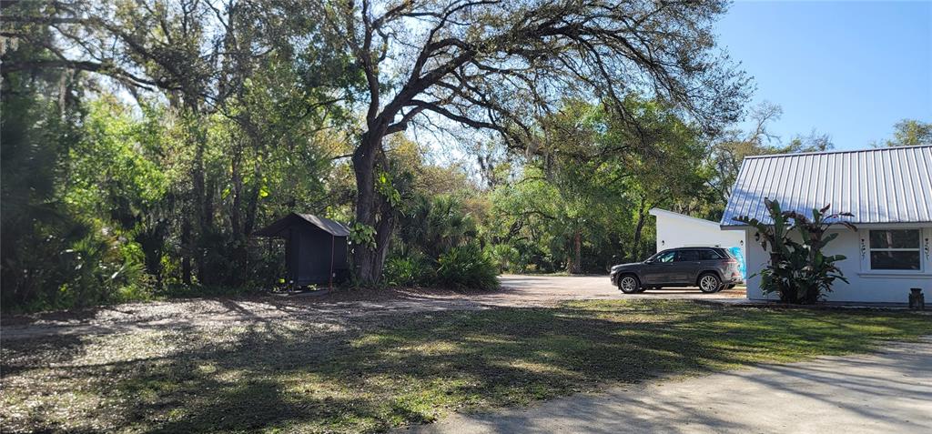 A gravel driveway leads to a house with a metal roof and a parked SUV — 6610 MCKOWN ROAD, SARASOTA, FL