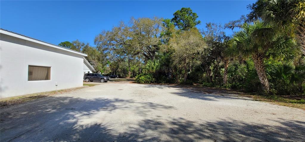 A gravel parking area sits beside a white building with a single window — 6610 MCKOWN ROAD, SARASOTA, FL