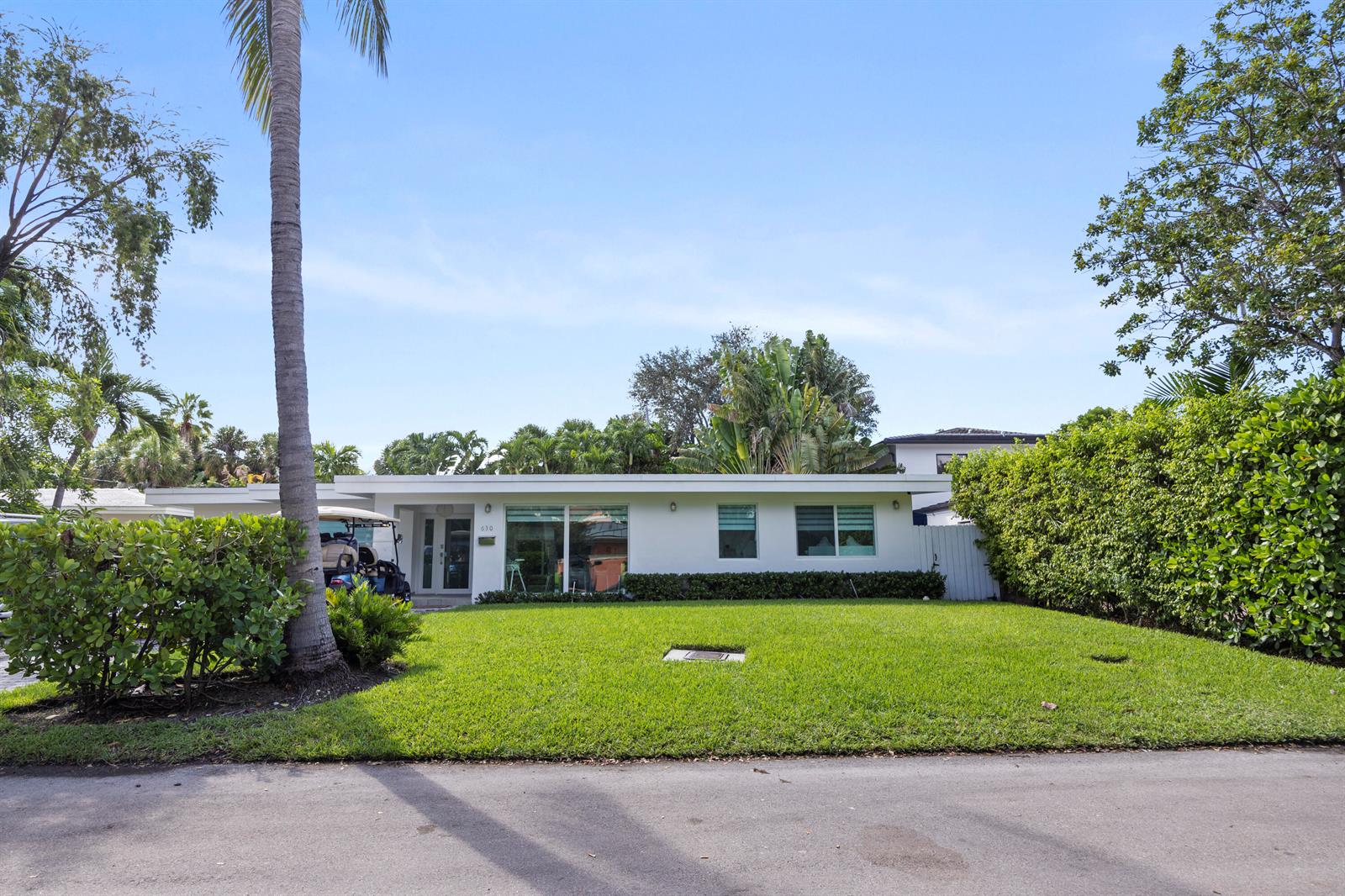 A single-story white house with a flat roof sits behind a green lawn — 630 Allendale Road, Key Biscayne FL 33149, KEY BISCAYNE, FL