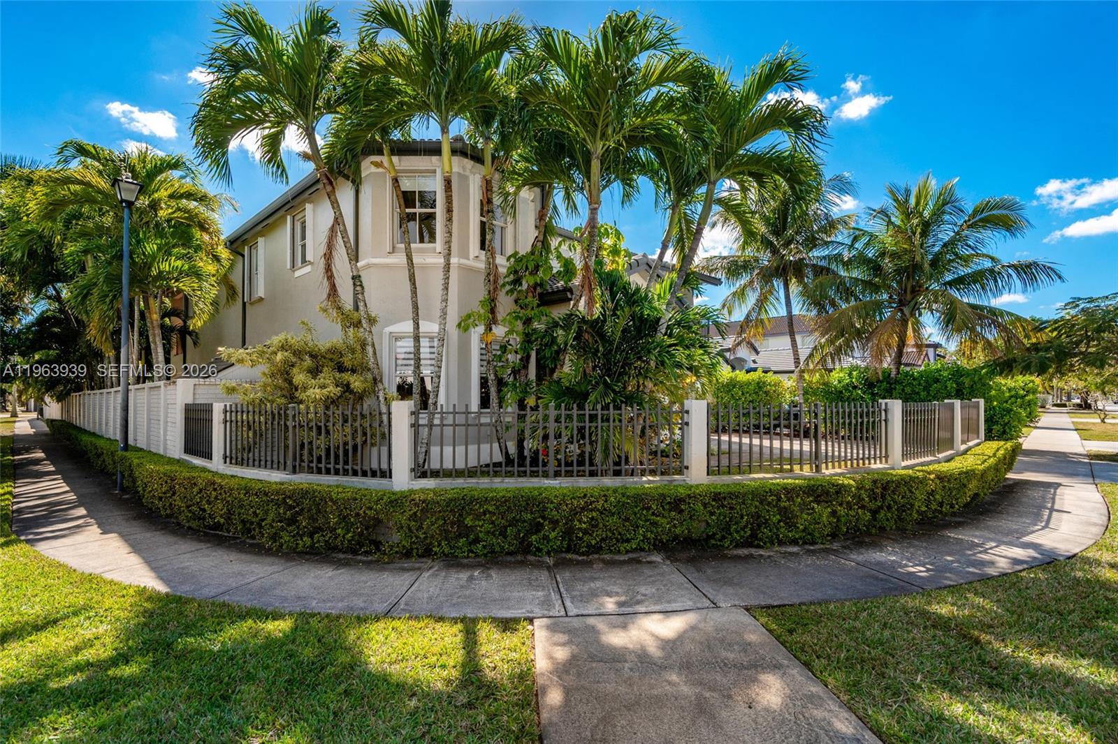 A two-story house with palm trees, a metal fence, and a sidewalk in front — 14900 SW 10th St, Miami FL 33194, MIAMI, FL