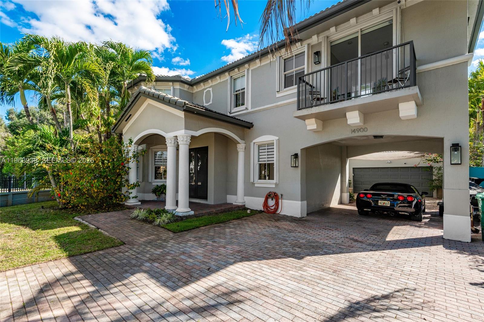 A two-story house with a brick driveway, a covered carport, and a second-floor balcony — 14900 SW 10th St, Miami FL 33194, MIAMI, FL