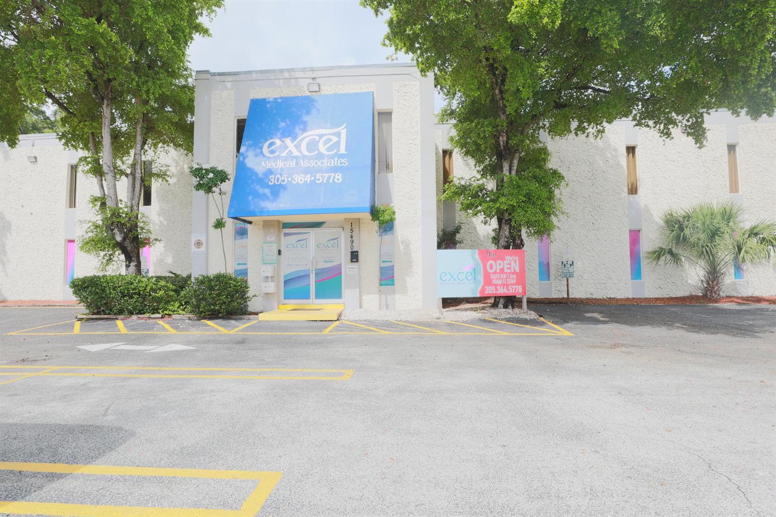The exterior of a two-story medical office building features a blue awning and parking lot — 15490 NW 7th Avenue # B, Miami FL 33169, MIAMI, FL