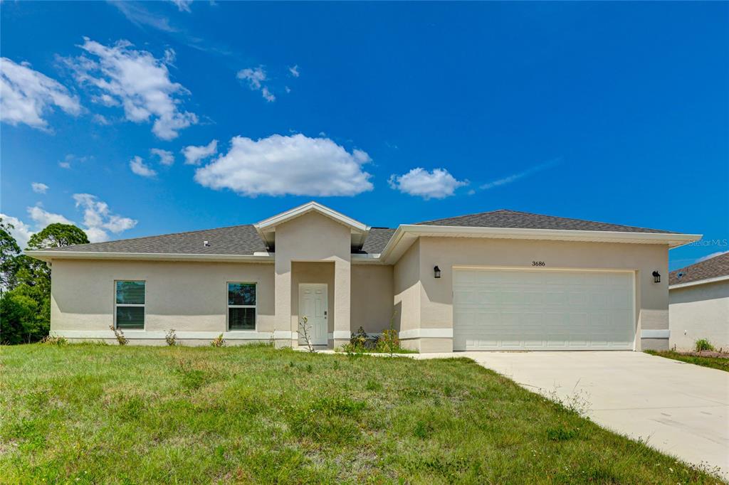 A single-story beige stucco house with a two-car garage and a concrete driveway — 3686 LUBEC AVENUE, NORTH PORT, FL