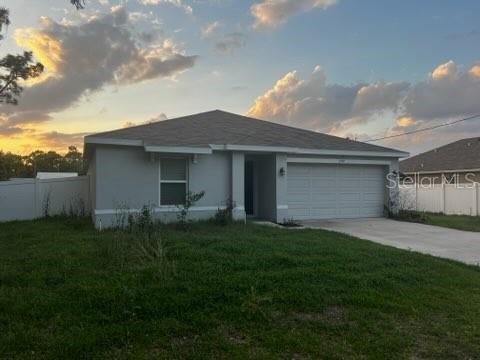 A single-story house with a gray exterior, a two-car garage, and a white vinyl fence — 3199 DELTONA BOULEVARD, SPRING HILL, FL